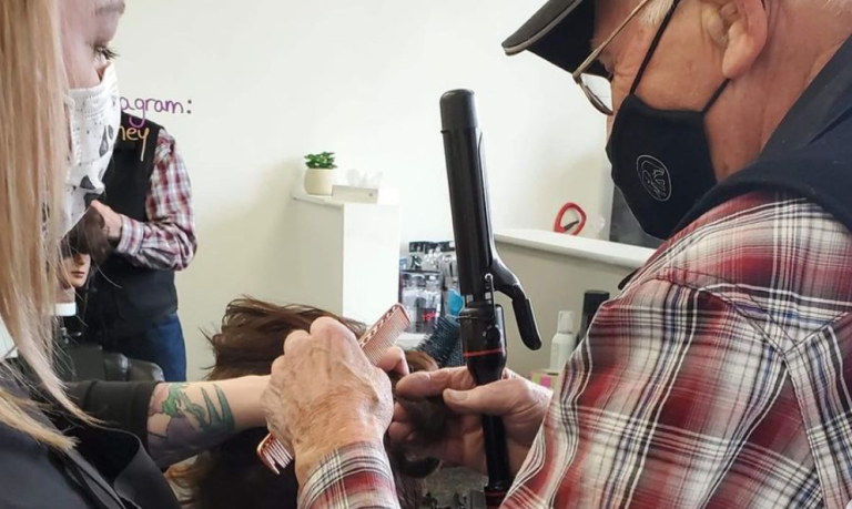 Adulto mayor acude a una peluquería para aprender a rizarle el pelo a su esposa