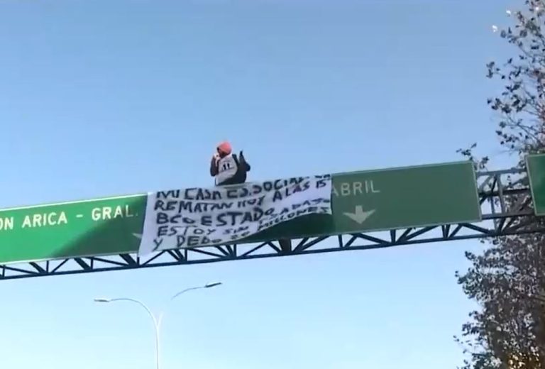 Hombre trepó a una señalética en Santiago para protestar por remate de su casa