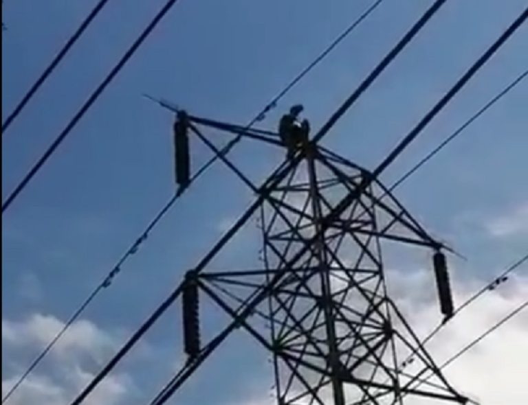 Hombre se mantiene en cima de torre de electricidad en Cerrillos