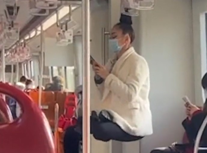 Insólito: Mujer se balancea con su cabello colgada del pasamanos de un tren